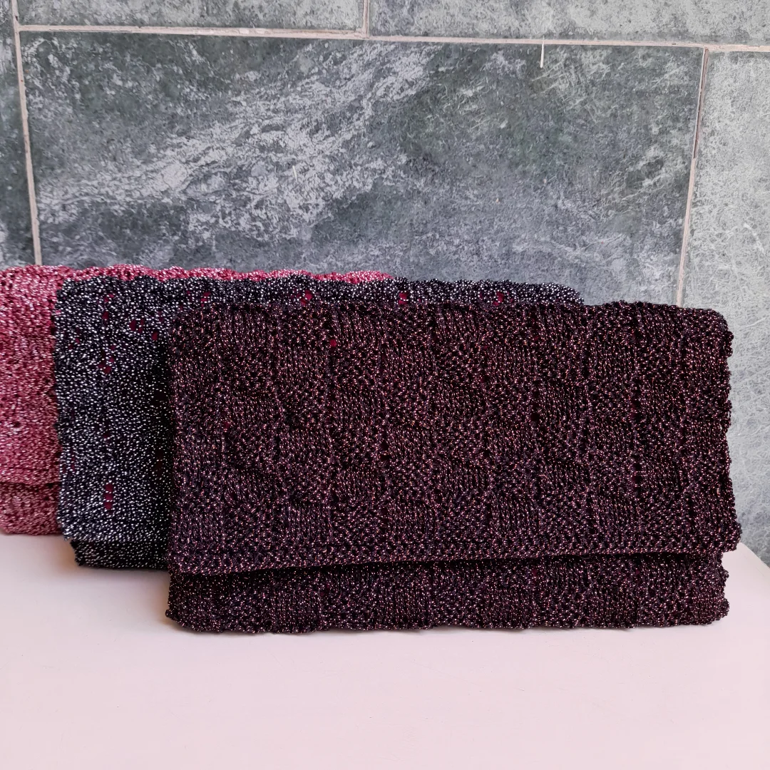 Three maroon metallic-yarn clutches laid together.