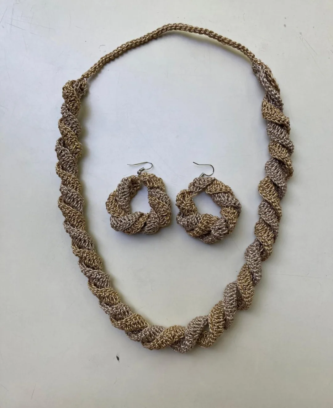 A gold bead-crochet necklace with matching earrings.