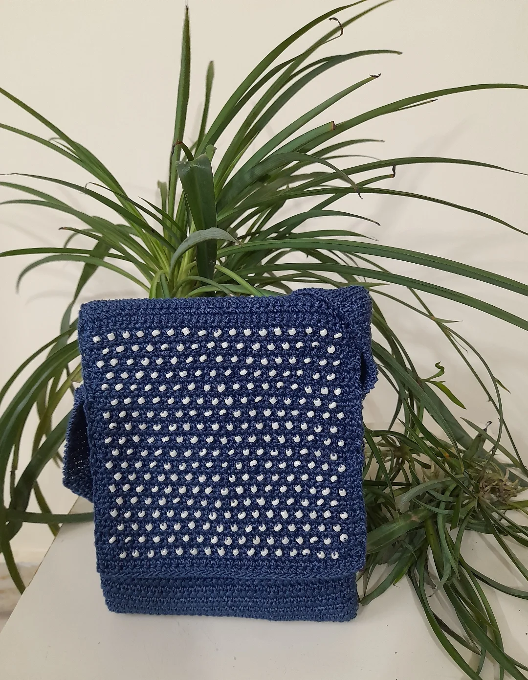 A navy crochet sling bag.