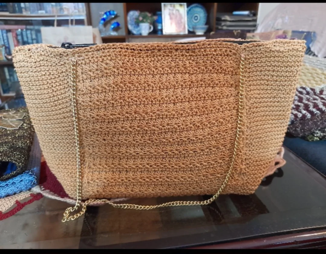 A gold tote worked in a star-pattern stitch with a chain strap.