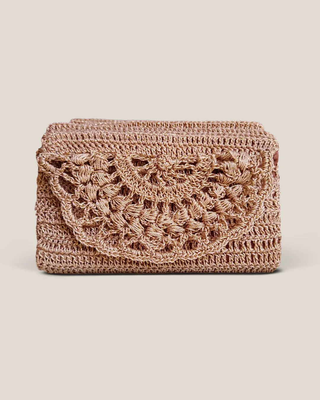 A rose-gold crochet clutch with a scalloped lace flap.